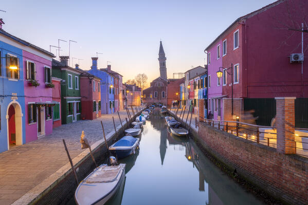 The leaning campanile of San Martino's church and the typical colored houses at dusk, Burano Island, Venice, Veneto, Italy.