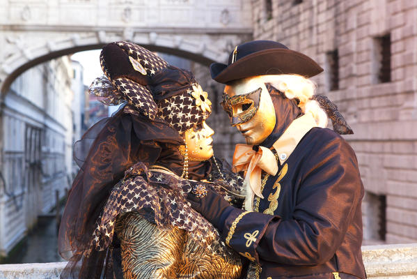 A couple of typical mask of Carnival of Venice with Bridge of Sighs on background, Venice, Veneto, Italy