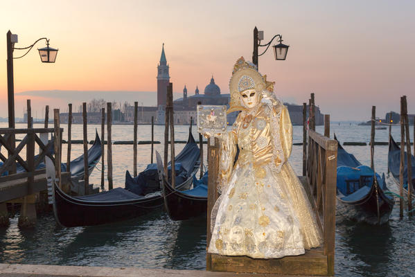 A typical mask of Carnival of Venice in Riva degli Schiavoni with San Giorgio Maggiore Island on background, Venice, Veneto, Italy