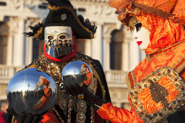 A couple of typical mask of Carnival of Venice with reflective spheres at San Marco square, Venice, Veneto, Italy