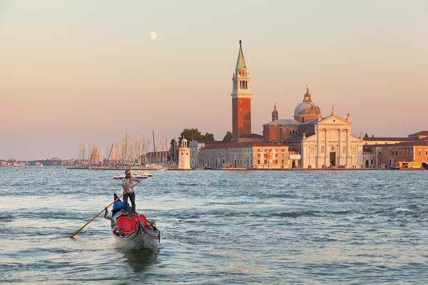 A gondola with St. George's island at sunset, Venice, Veneto, Italy