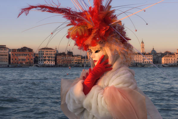 Typical mask of Carnival of Venice with palaces of Riva degli Schiavoni in the background, Venice, Veneto, Italy