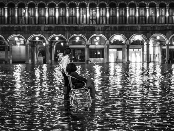 People observe the high tide in St. Mark's square, Venice, Veneto, Italy