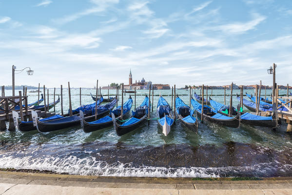 Gondolas of Venice in Riva degli Schiavoni with St. George's island in the background, Venice, Veneto, Italy