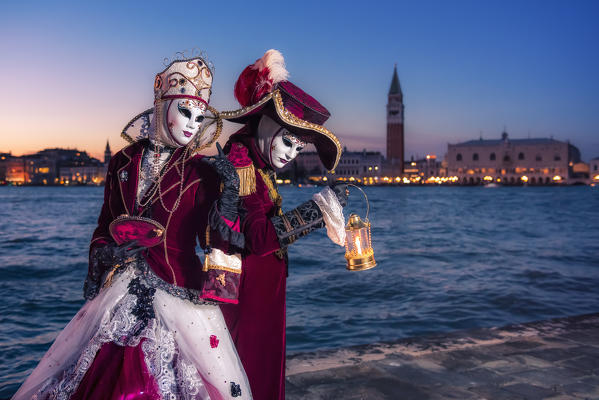 Typical mask of Carnival of Venice with the bell tower of St. Mark and the Doge's Palace in the background, Venice, Veneto, Italy