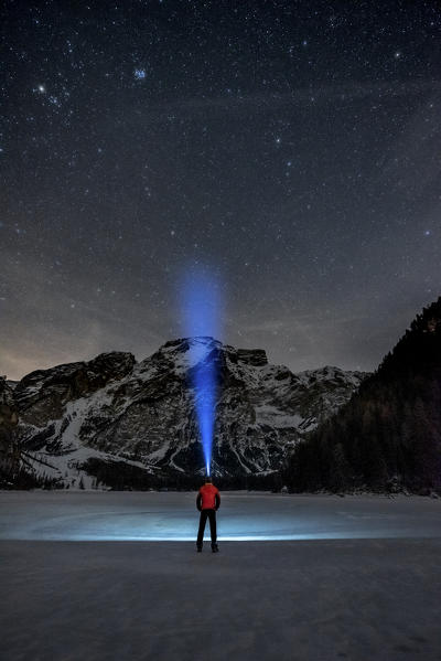 Braies/Prags, Dolomites, South Tyrol, Italy. 
Man admires the mount Seekofel at the frozen Lake Braies
