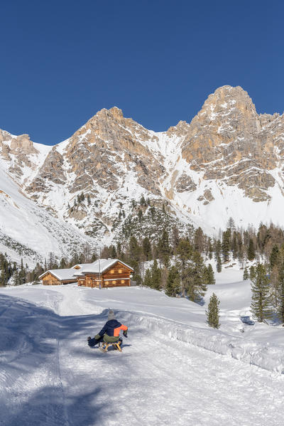 San Vigilio di Marebbe, Fanes, Dolomites, South Tyrol, Italy, Europe. Child sled down from the refuge Fanes