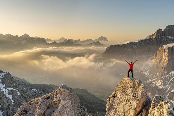 Gran Cir, Gardena Pass, Dolomites, Bolzano district, South Tyrol, Italy, Europe. A mountaineer admires the sunrise at the summit of the Gran Cir (MR)