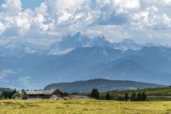 Villandro / Villanders, Bolzano province, South Tyrol, Italy. Alpine hut on the Villandro Alp with the Odle peaks in the background