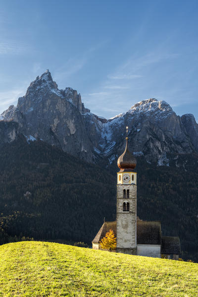 Kastelruth / Castelrotto, province of Bolzano, Dolomites, South Tyrol, Italy. The church of St. Valentin in Kastelruth/Castelrotto. In the background the jagged rocks of the Schlern/Sciliar