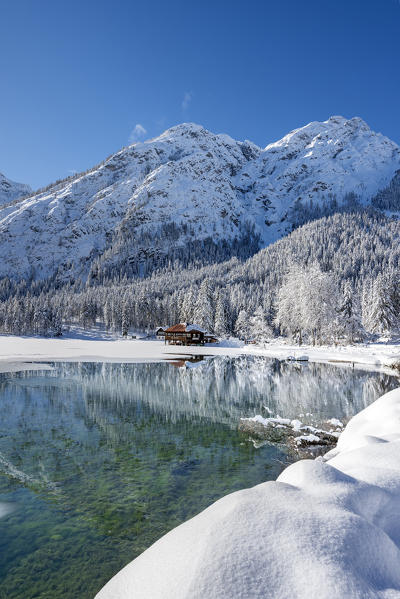 Dobbiaco/Toblach, province of Bolzano, South Tyrol, Italy. Winter at the Lake Dobbiaco, in the background the Mount Sarlkofel