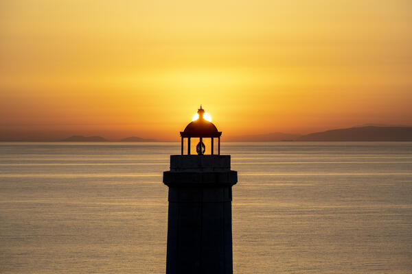 Otranto, province of Lecce, Salento, Apulia, Italy. Sunrise at the lighthouse Faro della Palascìa. This lighthouse marks the most easterly point of the Italian mainland.  In the background you can see mountains of Albania