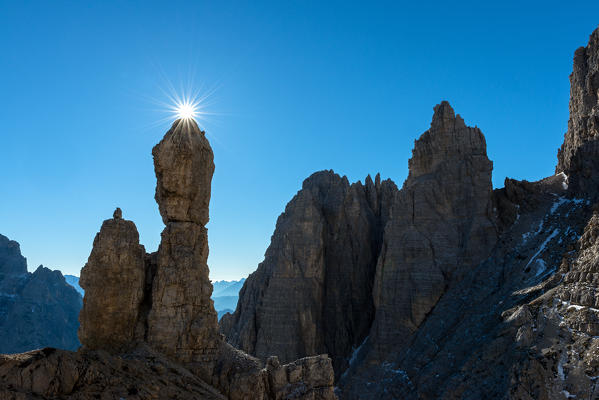 Auronzo, Dolomites, Veneto, Italy. Star sun exactly on the summit of Salsiccia near Refuge Carducci