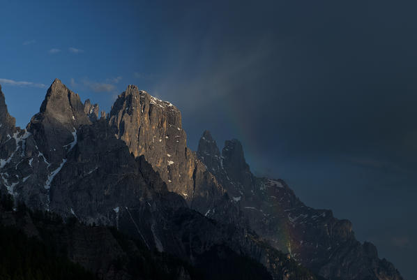 Passo Rolle, Dolomites, Trentino, Italy. Rainbow in the Pala mountains with the peaks of Cima di Ball and Sass Maor