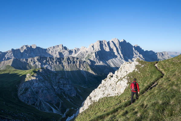 Odle di Eores, Dolomites, South Tyrol, Italy. Hikers on the trail Guenther Messner. In the background the Odle / Geisler