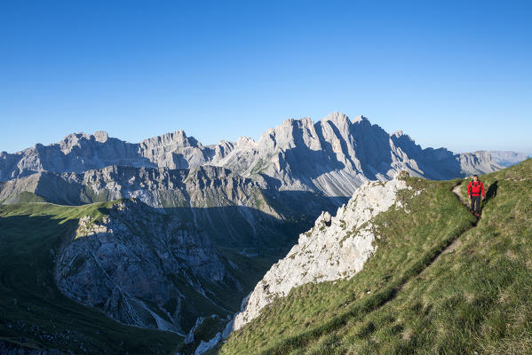 Odle di Eores, Dolomites, South Tyrol, Italy. Hikers on the trail Guenther Messner. In the background the Odle / Geisler