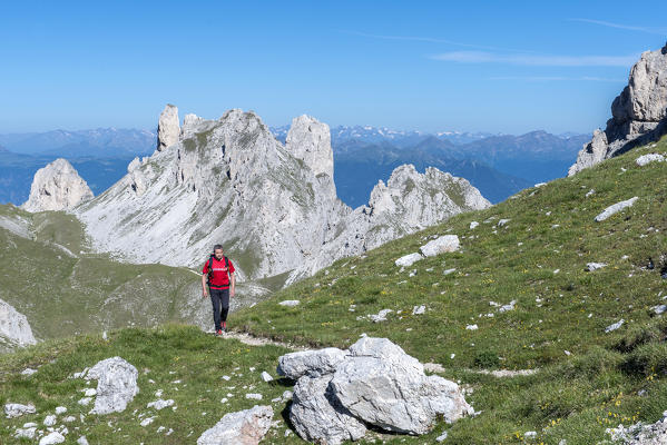 Funes Valley, Dolomites, South Tyrol, Italy. Hiker on the Alta Via Guenther Messner. In the background the peaks of Weisslahn
