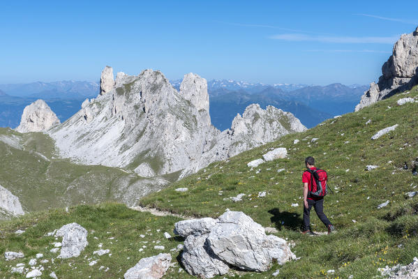Odle di Eores, Dolomites, South Tyrol, Italy. Hiker on the Alta Via Guenther Messner. In the background the peaks of Weisslahn