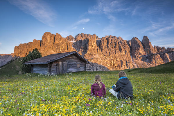 Passo Gardena, Dolomites South Tyrol, Italy. Children admire the alpenglow on the mountains of Sella