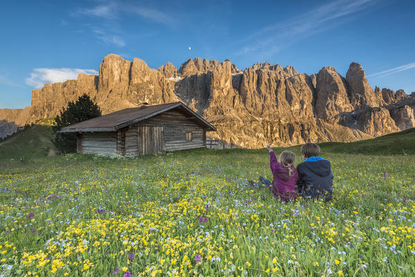 Passo Gardena, Dolomites South Tyrol, Italy. Children admire the alpenglow on the mountains of Sella