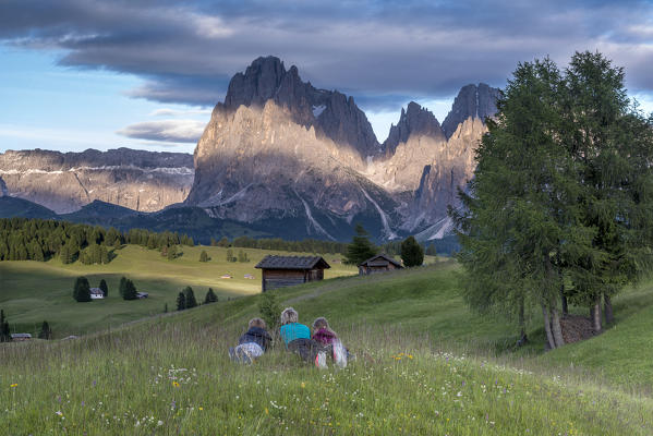 Alpe di Siusi/Seiser Alm, Dolomites, South Tyrol, Italy. Mountaineers on the Alpe di Siusi admire the alpenglow. In the background the Sella, Sassolungo/Langkofel and Sassopiatto/Plattkofel