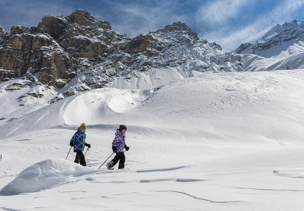 Fanes, Dolomites, South Tyrol, Italy. Children wearing snowshoes walking in the mountains of the Fanes