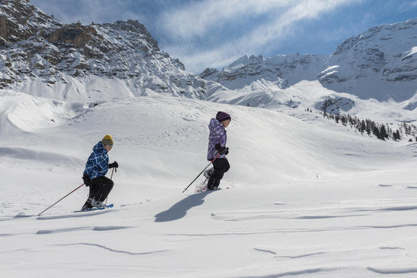 Fanes, Dolomites, South Tyrol, Italy. Children wearing snowshoes walking in the mountains of the Fanes