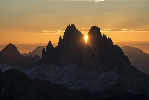 Picco di Vallandro, Prato Piazza, Dolomites, South Tyrol, Italy. The sun rises exactly in between the crags of the Tre Cime di Lavaredo. This effect occurs only few days per year, exactly during winter solstice days