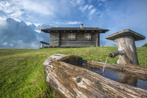 Passo Gardena, Dolomites, South Tyrol, Italy. Mountain hut in front of the mountains of the Sella group