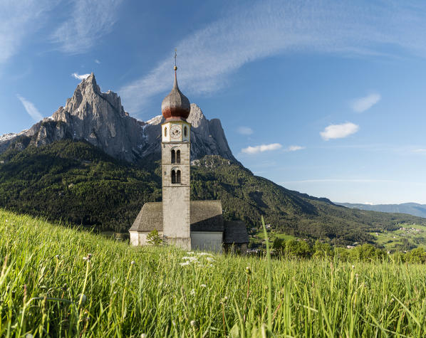 Kastelruth / Castelrotto, Dolomites, South Tyrol, Italy. The church of St. Valentin in Kastelruth/Castelrotto. In the background the jagged rocks of the Schlern/Sciliar