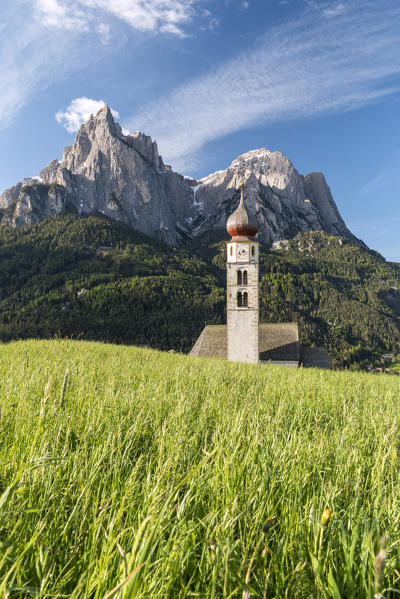 Kastelruth / Castelrotto, Dolomites, South Tyrol, Italy. The church of St. Valentin in Kastelruth/Castelrotto. In the background the jagged rocks of the Schlern/Sciliar