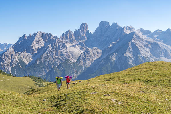 Prato Piazza/Plätzwiese, Dolomites, South Tyrol, Italy. Two children hike over the Prato Piazza/Plätzwiese. In the background the mountain group of Cristallo