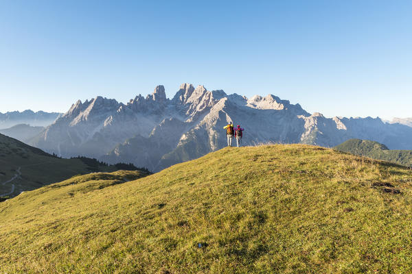 Prato Piazza/Plätzwiese, Dolomites, South Tyrol, Italy. Two children admire the mountains above the Prato Piazza/Plätzwiese. In the background the mountain group of Cristallo