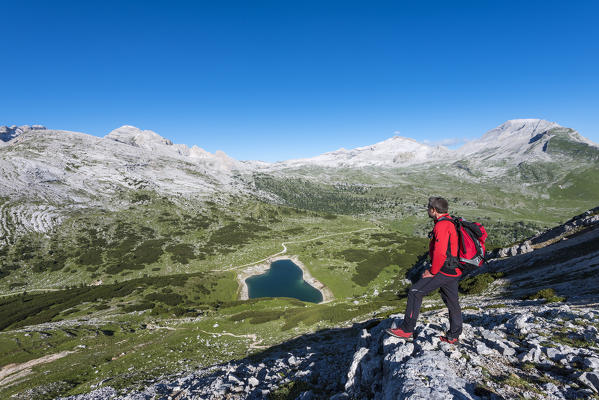 Fanes, Dolomites, South Tyrol, Italy. The refuge Lavarella. Hiker ascend to the Col Becchei