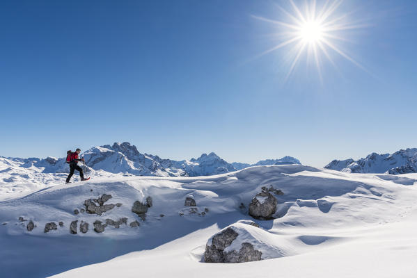 San Vigilio di Marebbe, Sennes, Dolomites, Bolzano province, South Tyrol, Italy. A view of a hiker going up a hill with snowshoes 