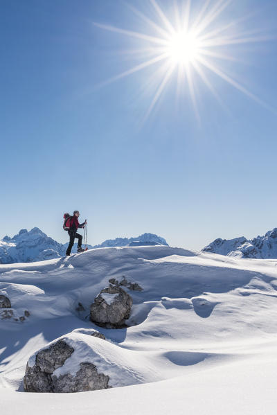 San Vigilio di Marebbe, Sennes, Dolomites, Bolzano province, South Tyrol, Italy. A view of a hiker going up a hill with snowshoes 