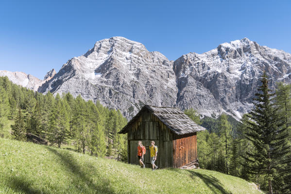 La Valle / Wengen, Alta Badia, Bolzano province, South Tyrol, Italy. Hikers traveling on the pastures of Pra de Rit