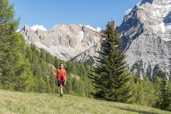 La Valle / Wengen, Alta Badia, Bolzano province, South Tyrol, Italy. Young hiker traveling on the pastures of Pra de Rit