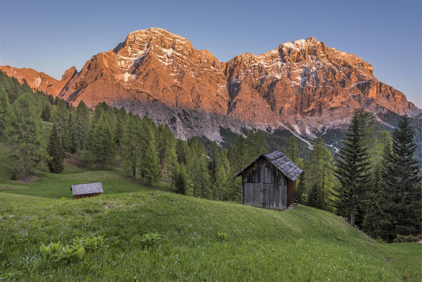 La Valle / Wengen, Alta Badia, Bolzano province, South Tyrol, Italy. Sunset on the pastures of Pra de Rit with the peaks Cima Nove / Neunerspitze and Cima Dieci / Zehnerspitze