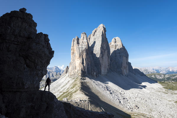 Sesto / Sexten, province of Bolzano, Dolomites, South Tyrol, Italy. Silhouette of a mountaineer in front of the Three Peaks of Lavaredo