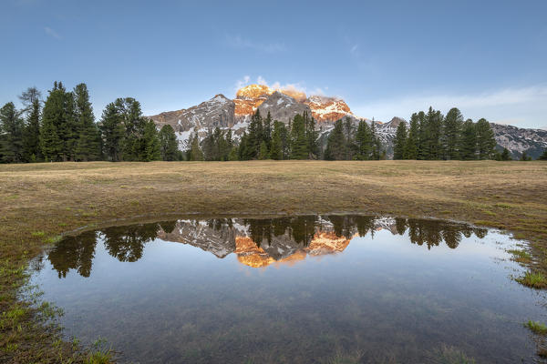 Prato Piazza/Plätzwiese, Dolomites, South Tyrol, Italy. The Croda Rossa d'Ampezzo is reflected at sunrise in a pool on the Prato Piazza