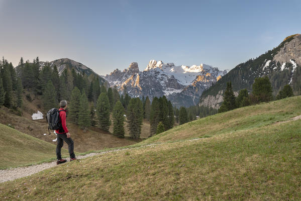 Prato Piazza/Plätzwiese, Dolomites, South Tyrol, Italy. A hiker on the Prato Piazza admires the Cristallo massif at sunrise (MR)