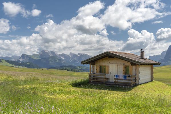 Alpe di Siusi/Seiser Alm, Dolomites, South Tyrol, Italy. A littke mountain hut with the Odle mountains in the background