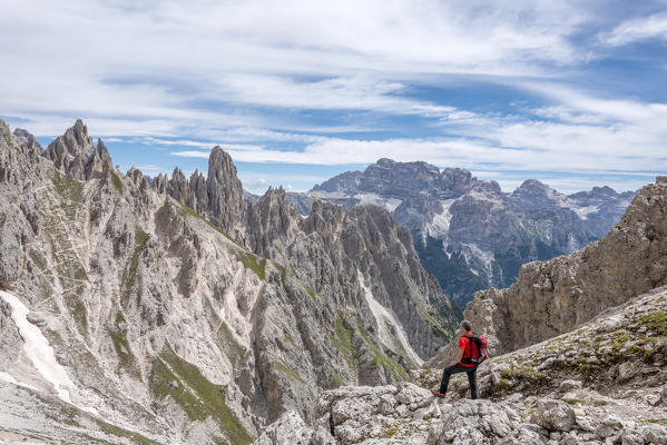 Misurina, Cadini mountains, Dolomites, province of Belluno, Veneto, Italy. A mountaineer admires the mountain panorama in the saddle Ciadin Deserto