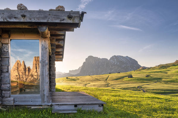 Alpe di Siusi/Seiser Alm, Dolomites, South Tyrol, Italy. Sunrise on the Alpe di Siusi/Seiser Alm. The peaks of the Sciliar are reflected in a glass pane