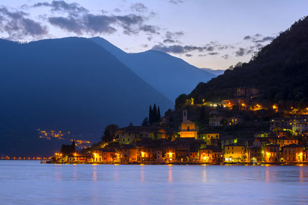 Peschiera Maraglio shortly after sunset, the lights of the small village of Montisola, the lake island more 'big in Europe, in the province of Brescia, Lake Iseo