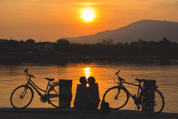 Pair of cyclists at sunset, iseo lake, Brescia province, Lombardy district, Italy.