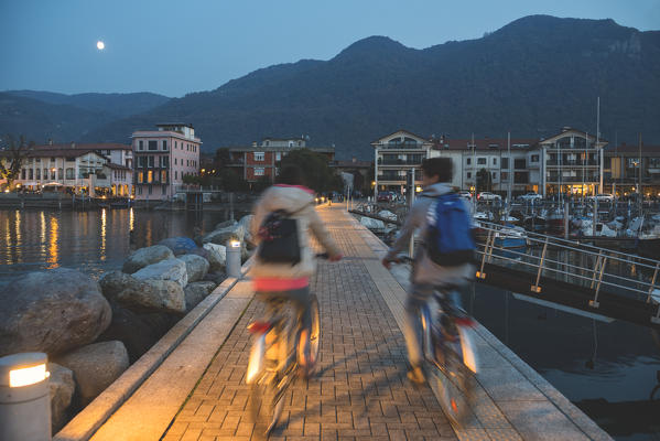 Pair of cyclists at sunset, iseo lake, Brescia province, Lombardy district, Italy.