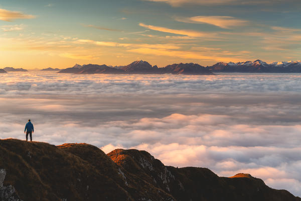 Trekker at Sunset from Mount Guglielmo above the Clouds, Brescia province, Lombardy district, Italy