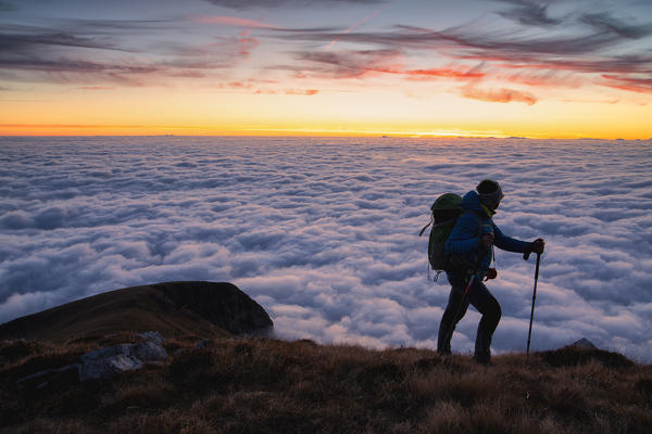 Trekker at Sunset from Mount Guglielmo above the Clouds, Brescia province, Lombardy district, Italy